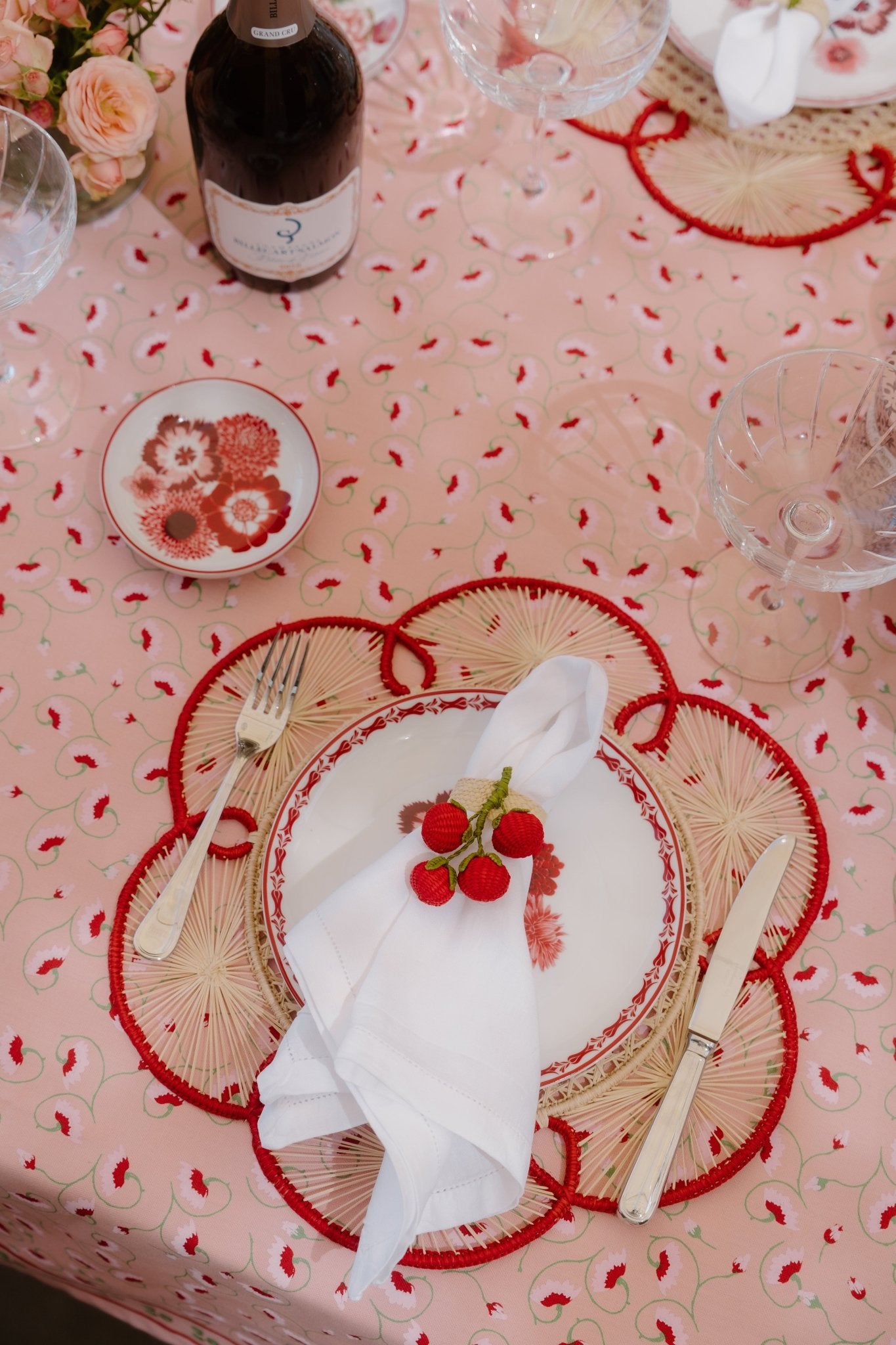 Red woven charger styled on Italian-inspired tablescape